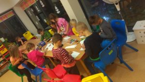 dzieci tworzące obrazki z wykorzystaniem różnych technik plastyczny : flamastry, kredki , farby, ozdoby z koralików