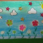 obrazek wykonany na kartce z bloku rysunkowego farbami i ozdobiony koralikami, przedstawia łąkę z kwiatkami i nad nią niebo pełne obłoków